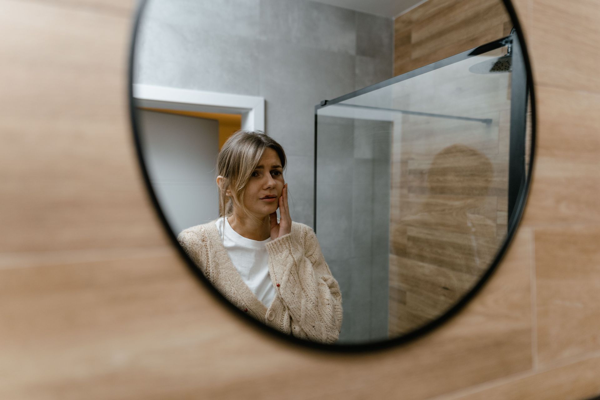 woman looking in a round mirror