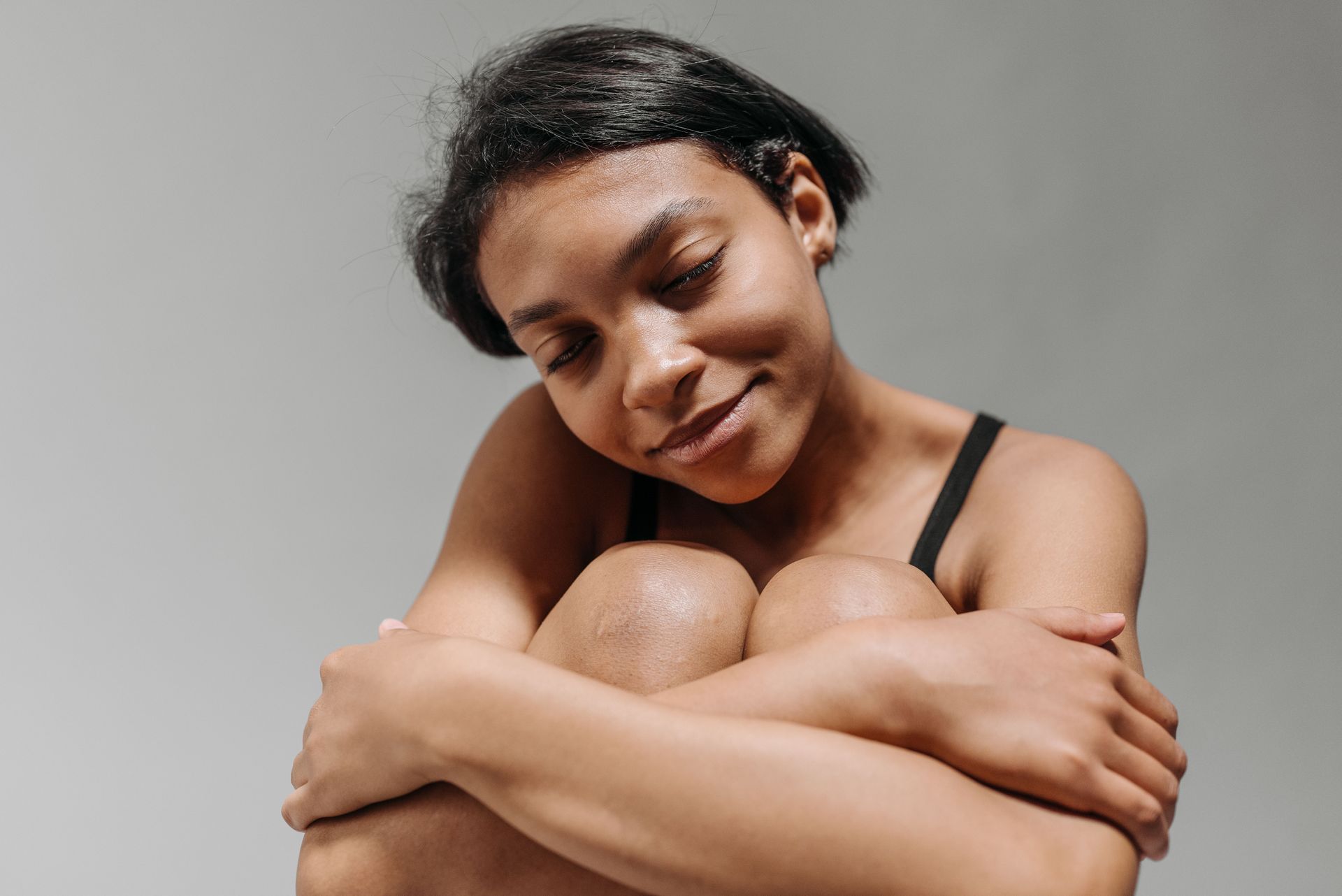 woman hugging her knees to body