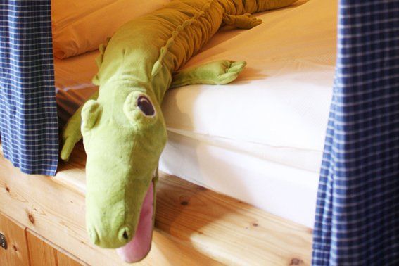 Stoffkrokodil guckt aus Butzenbett Tuskulum