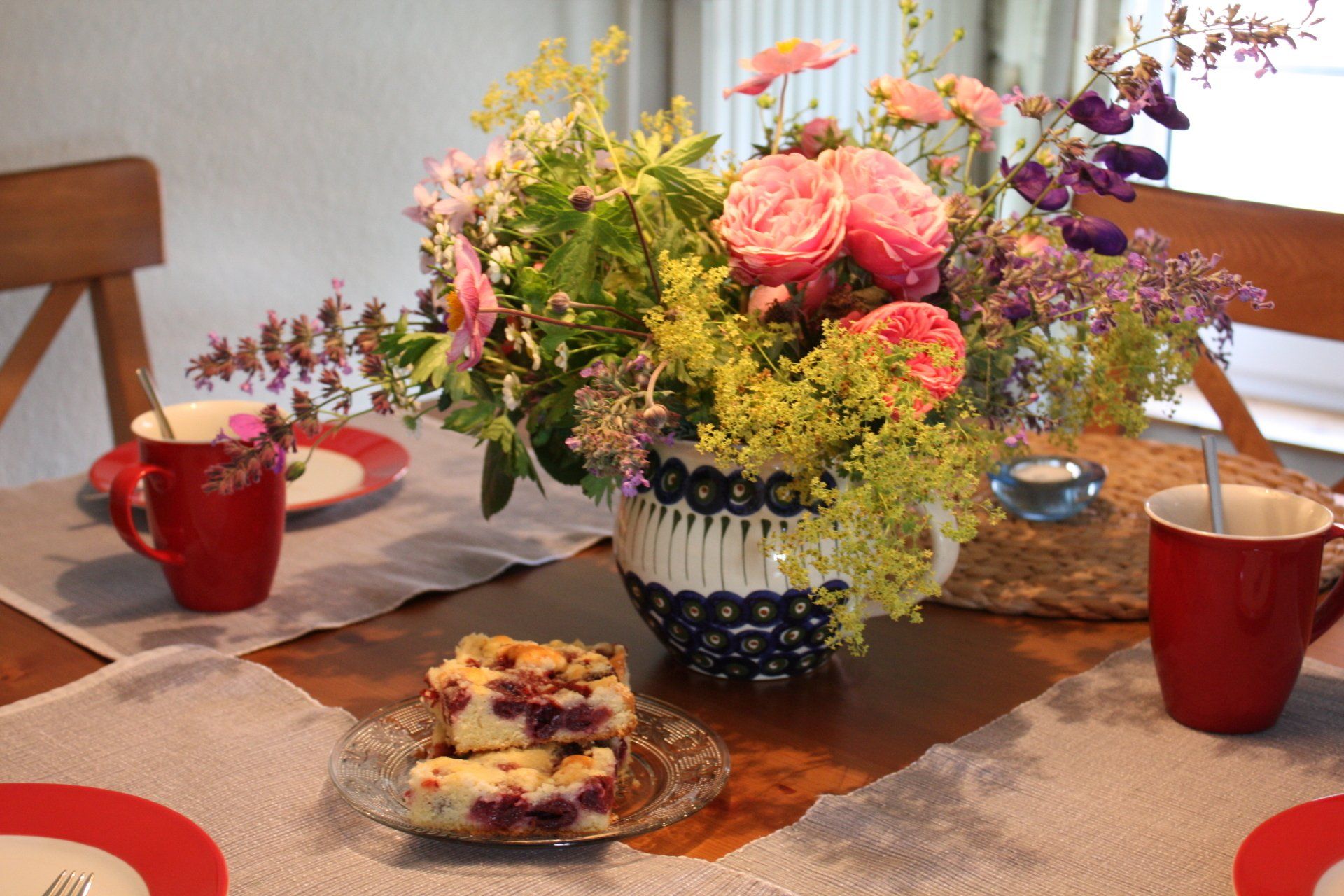 Tisch gedeckt mit Geschirr und Blumen