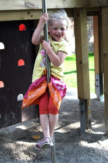 Mädchen rutscht von einer Stange runter