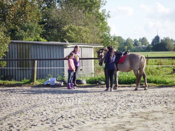 Drei Mädchen und Pony auf dem Reitplatz