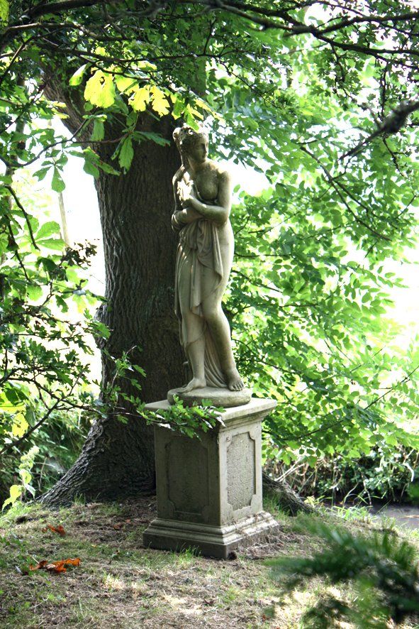Frauenstatue unter einem Baum