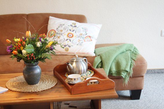 Couchecke mit Blumen und Teetablet Mittenmang