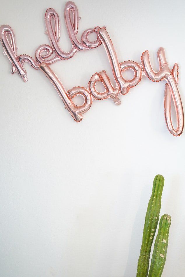 pink balloons on a wall say 'hello baby'