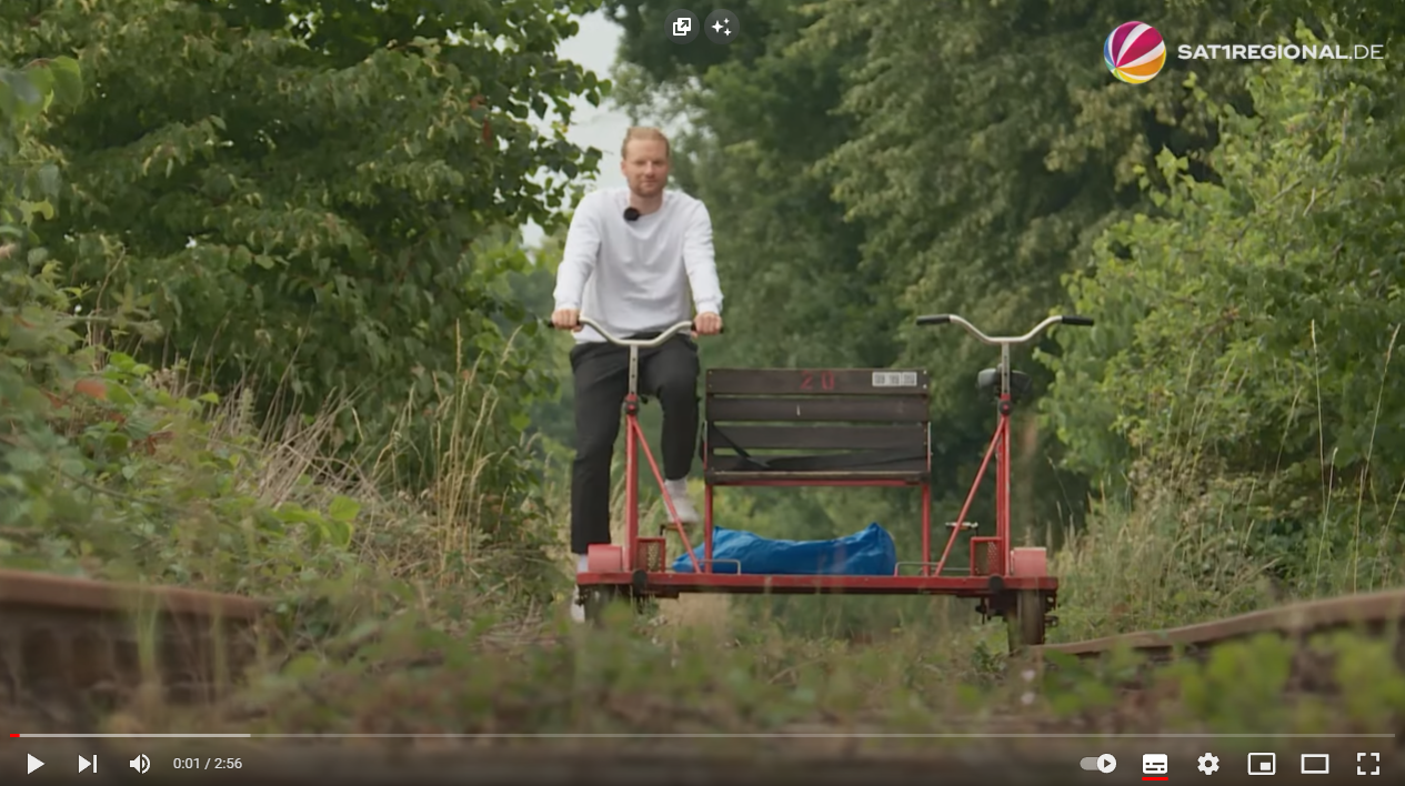 Link zum SAT-1-Video zur Bahnstrecke Malente-Lütjenburg Sven Ratjens auf der Fahrraddraisine auf der Bahnstrecke Malente-Lütjenburg