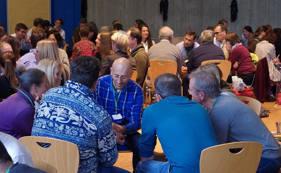 Teilnehmer einer Dialogveranstaltung in Minigruppen im Gespräch - Multi-Stakeholder