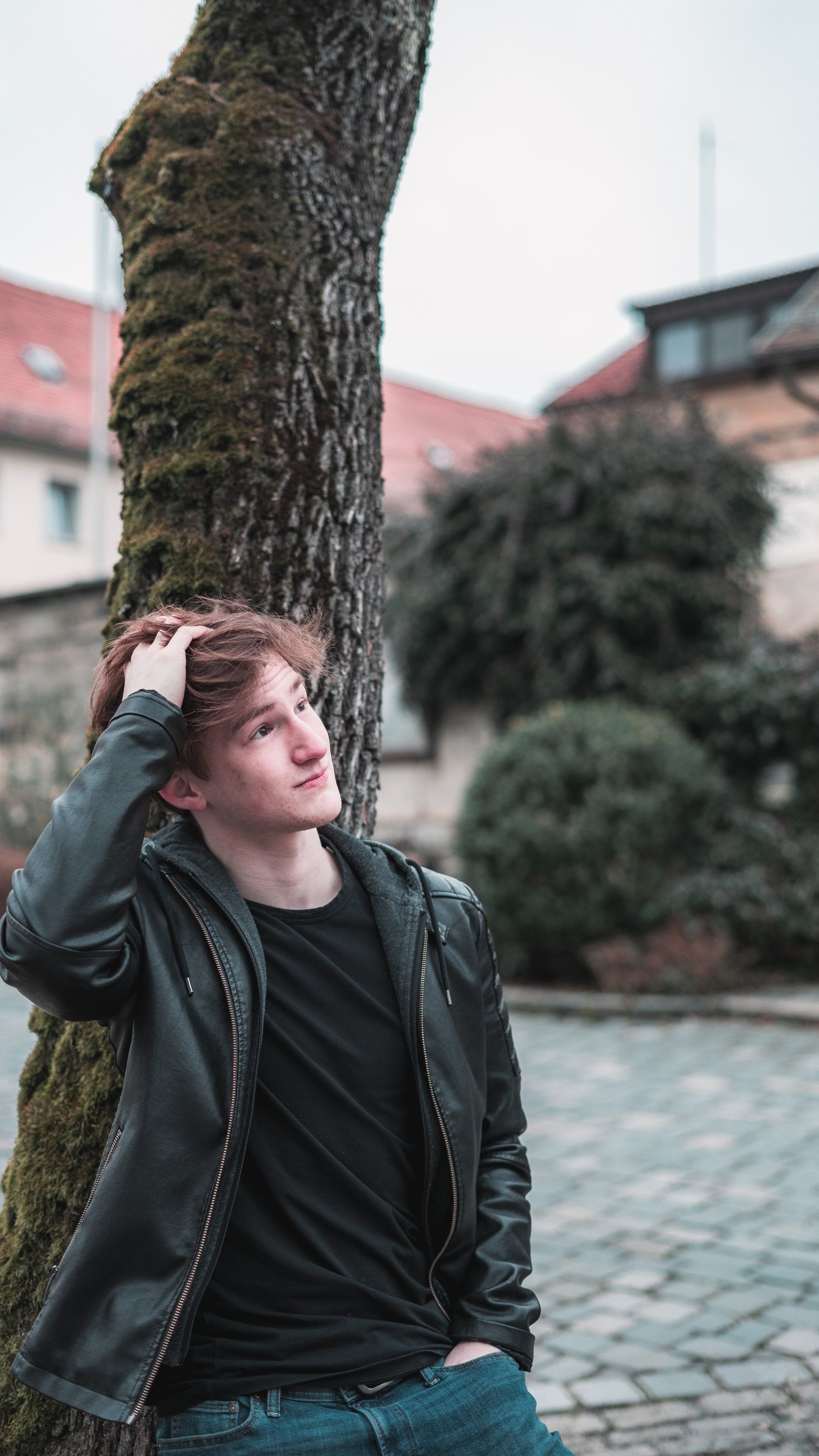 Portrait von jungen Mann in Lederjacke an Baum angelehnt, Bild von Fotograf Hannes Schmidt