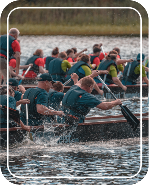 Team in einem Drachenboot rudert, Wasser spritzt hoch, Bild von Fotograf Hannes Schmidt