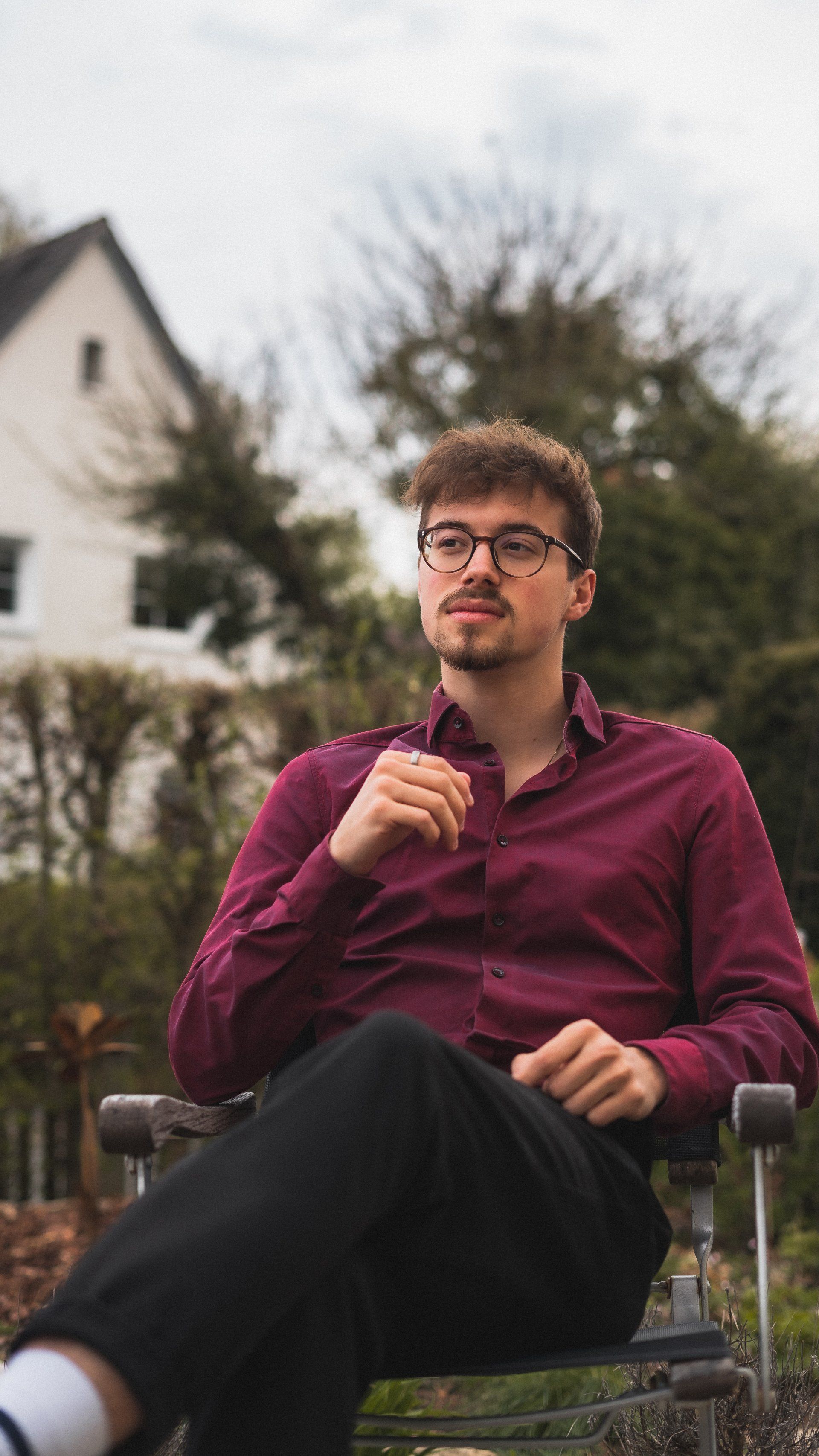 Portrait von Junger Mann in Rotem Hemd schaut zur Seite, Bild von Fotograf Hannes Schmidt