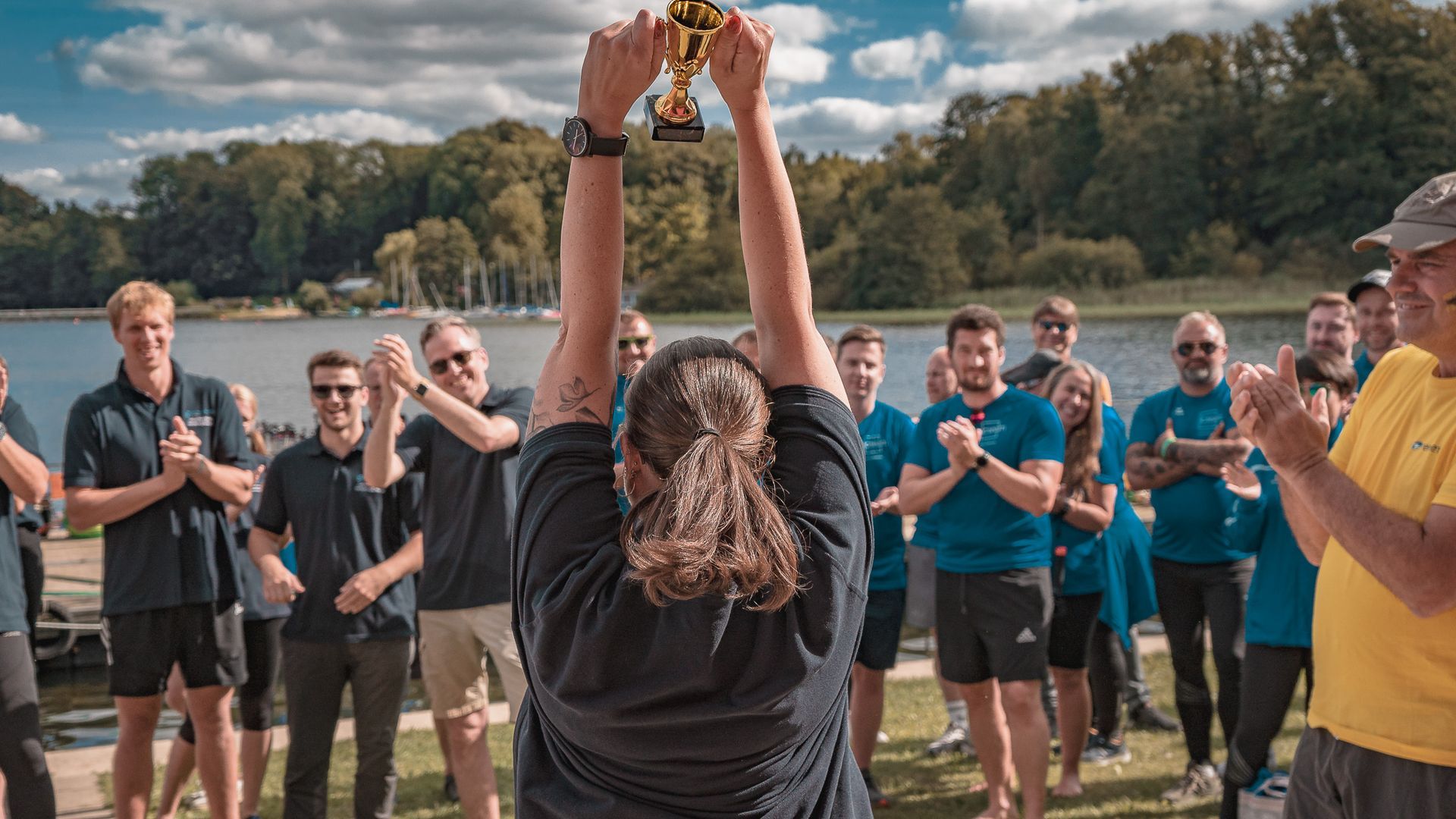 Siegerin hält Trophäe hoch vor ihrem Team, von Fotograf Hannes Schmidt in Aachen