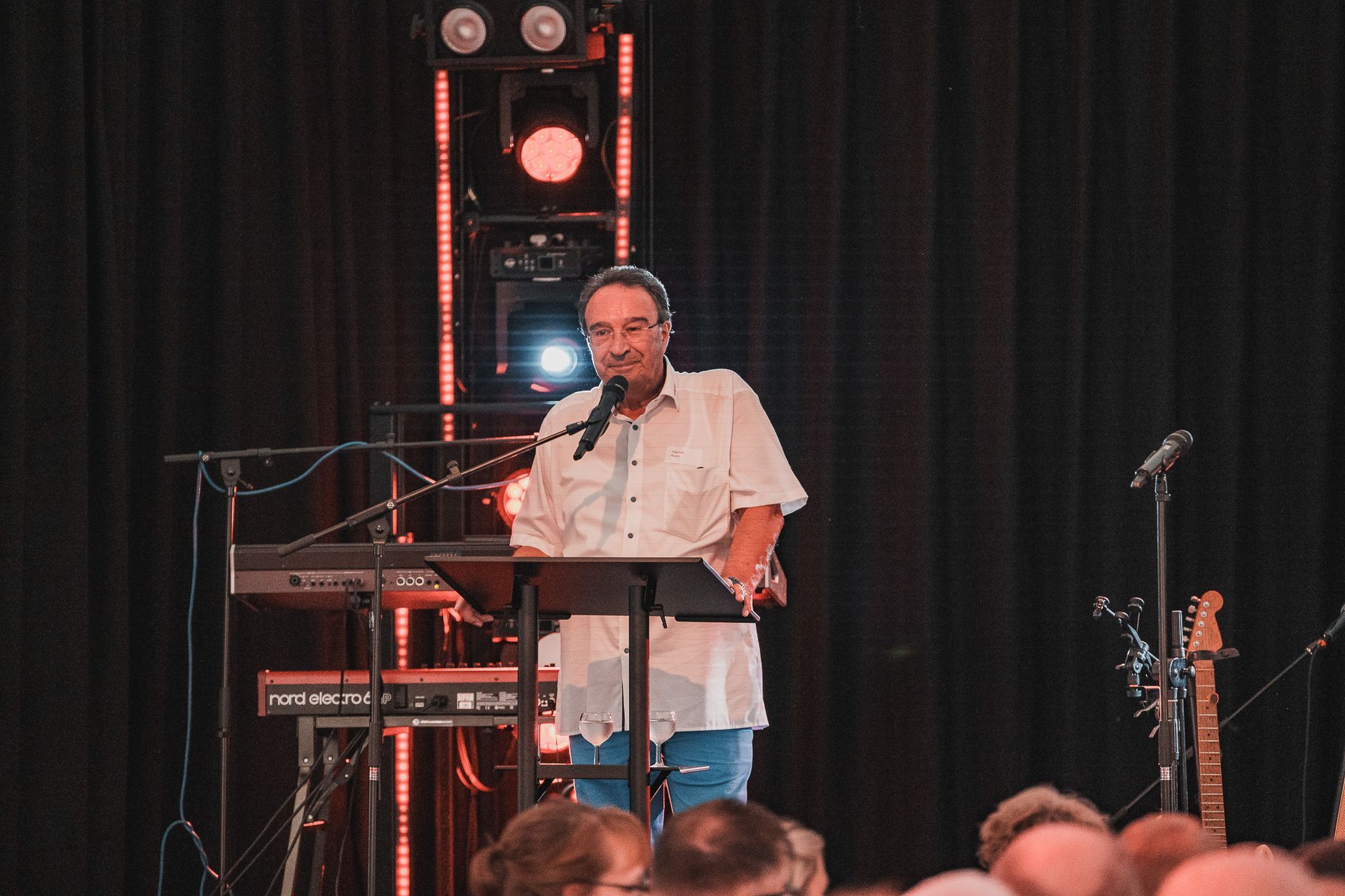 CEO steht bei Firmenfeier auf der Bühne in Rampenlicht, Foto von Fotograf Hannes Schmidt