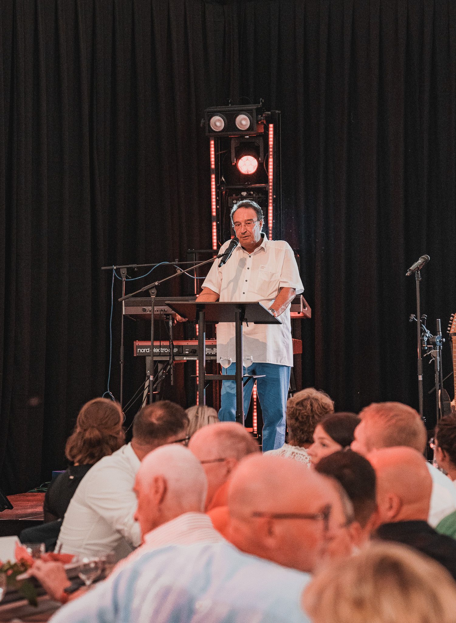 Rede vor einem Publikum auf einer Bühne bei einer Firmenfeier von Event Fotograf Hannes Schmidt in Aachen