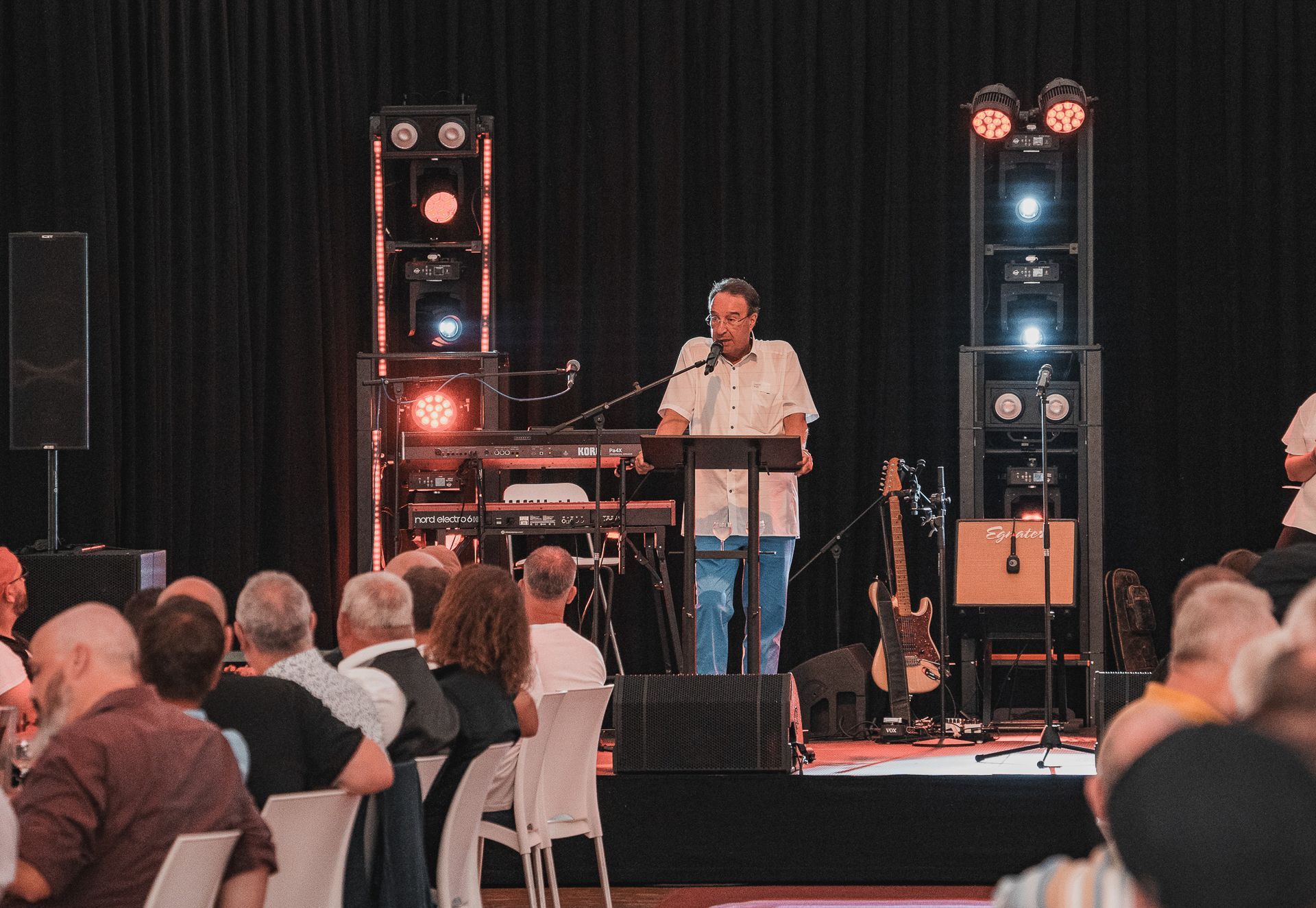 Rede vor einem Publikum mit Bühnenlicht bei einer Firmenfeier von Event Fotograf Hannes Schmidt in Aachen