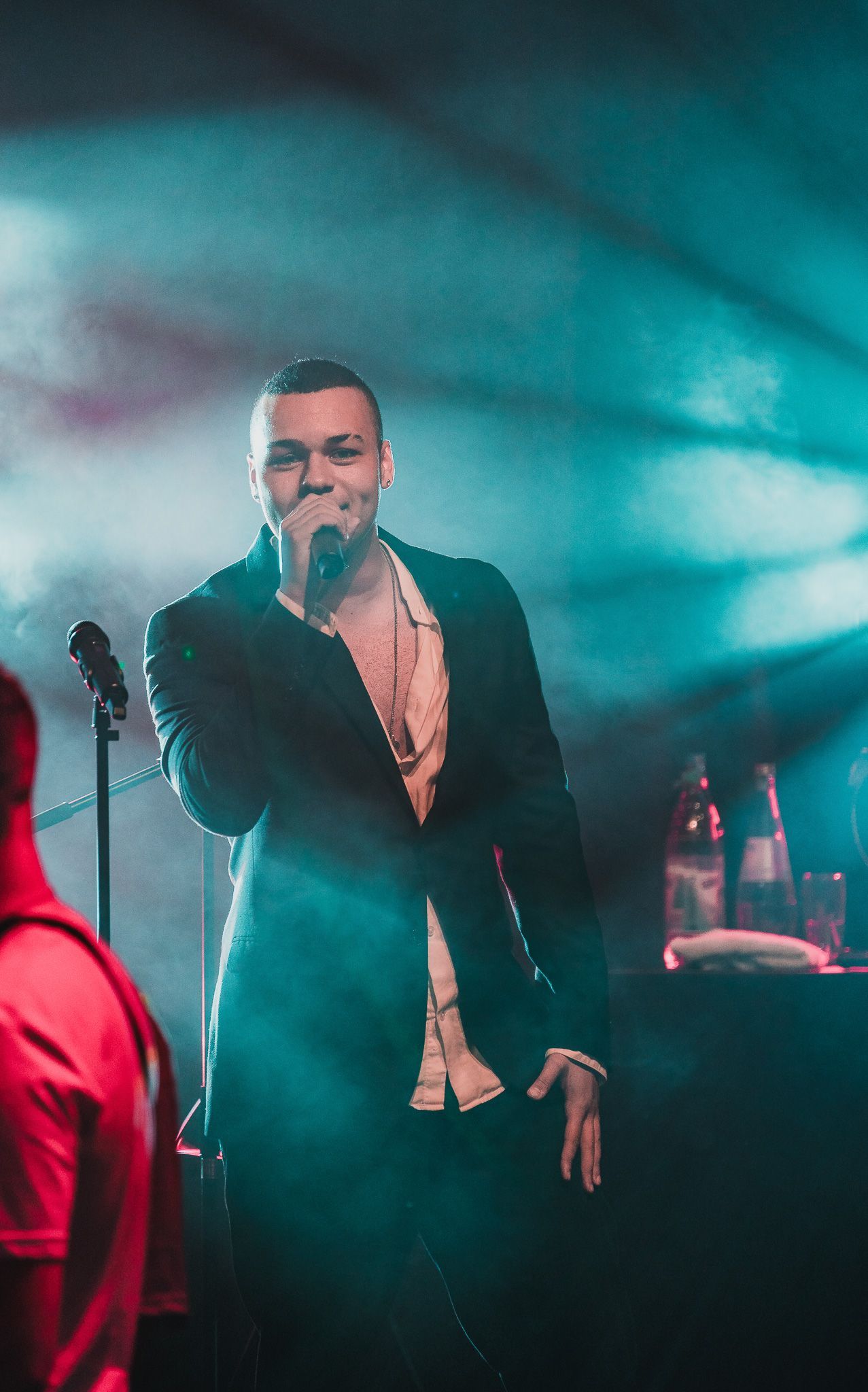 Sänger im Rampenlicht mit Mikrofon bei einer Firmenfeier von Event Fotograf Hannes Schmidt in Aachen
