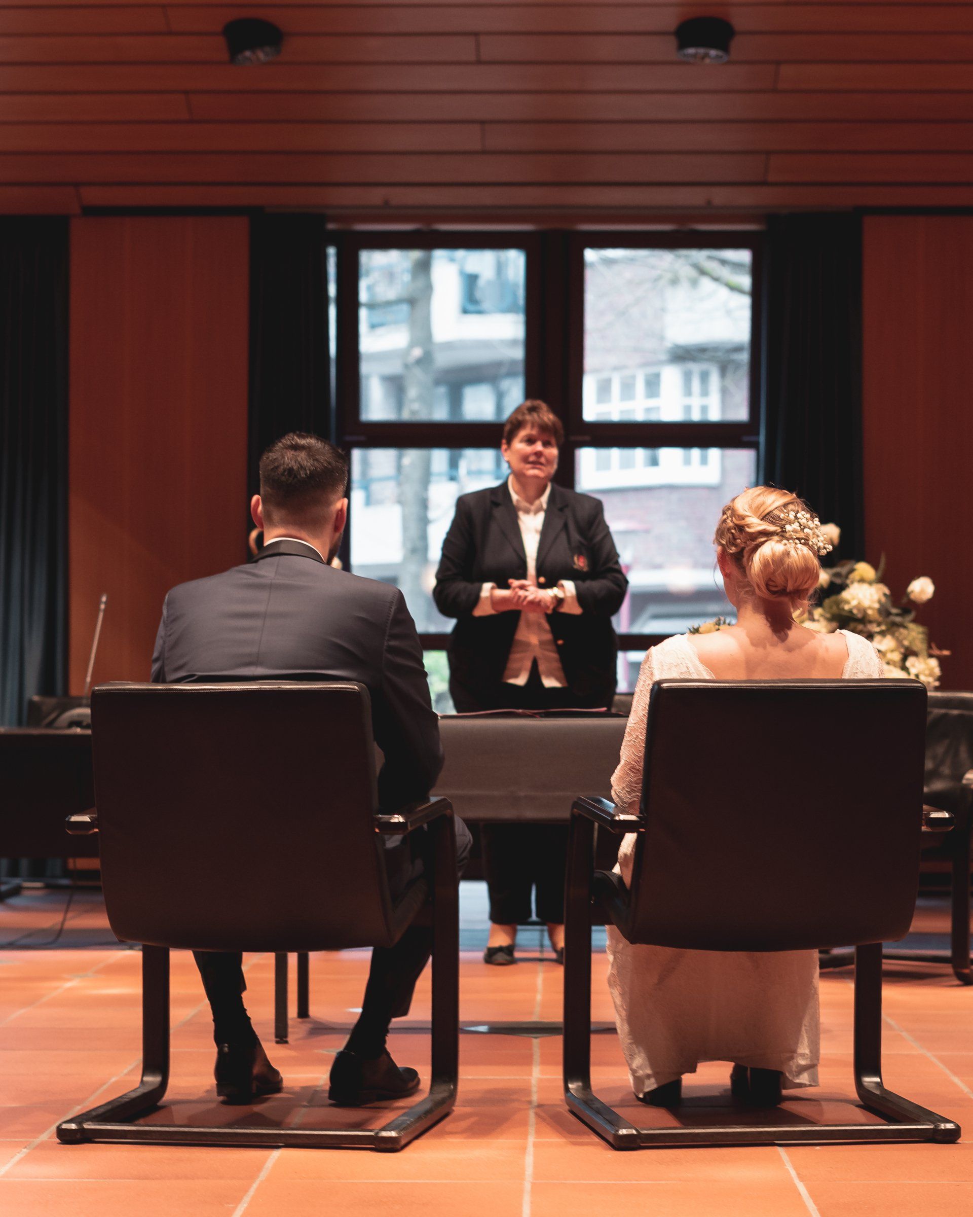 Brautpaar sitzt vor der Trauung durch Mitarbeiterin der Stadt von Fotograf Hannes Schmidt in Aachen