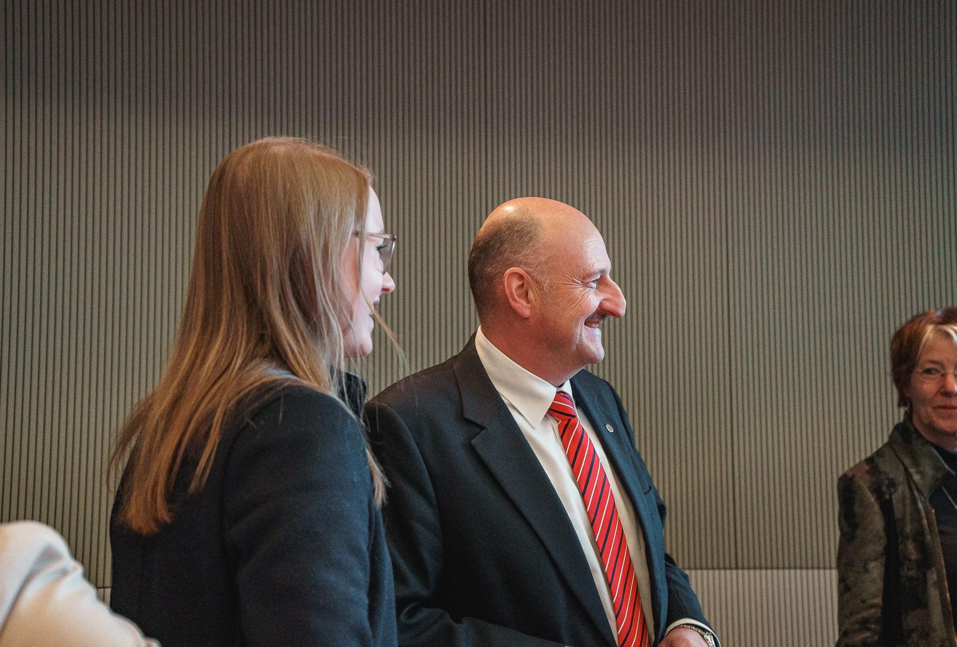Eine Frau und Mann in Anzug stehen nebeneinander und lächeln, von Fotograf Hannes Schmidt in Aachen