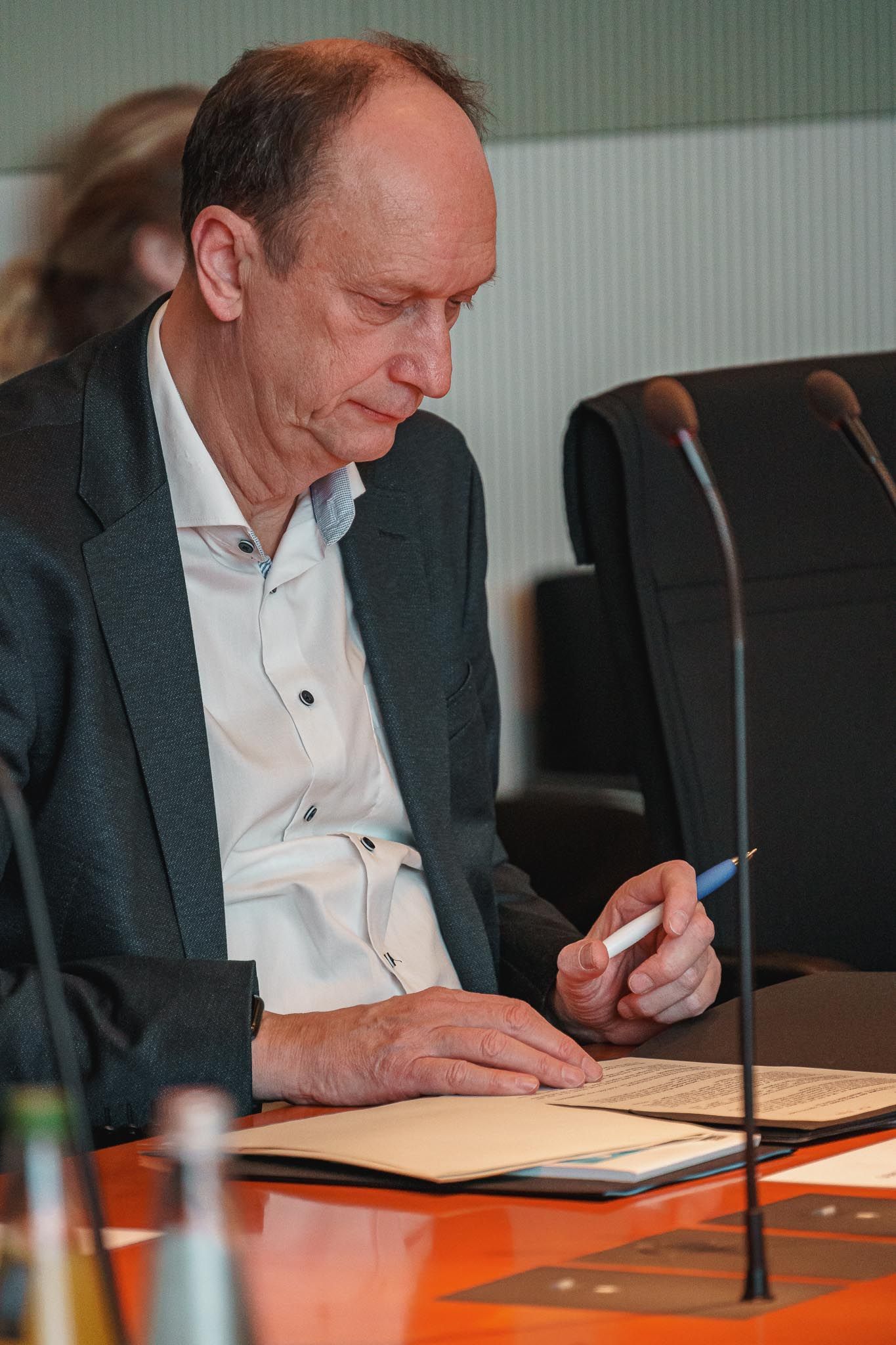 Alter Mann in Anzug guckt auf ein Blatt vor sich, von Fotograf Hannes Schmidt in Aachen