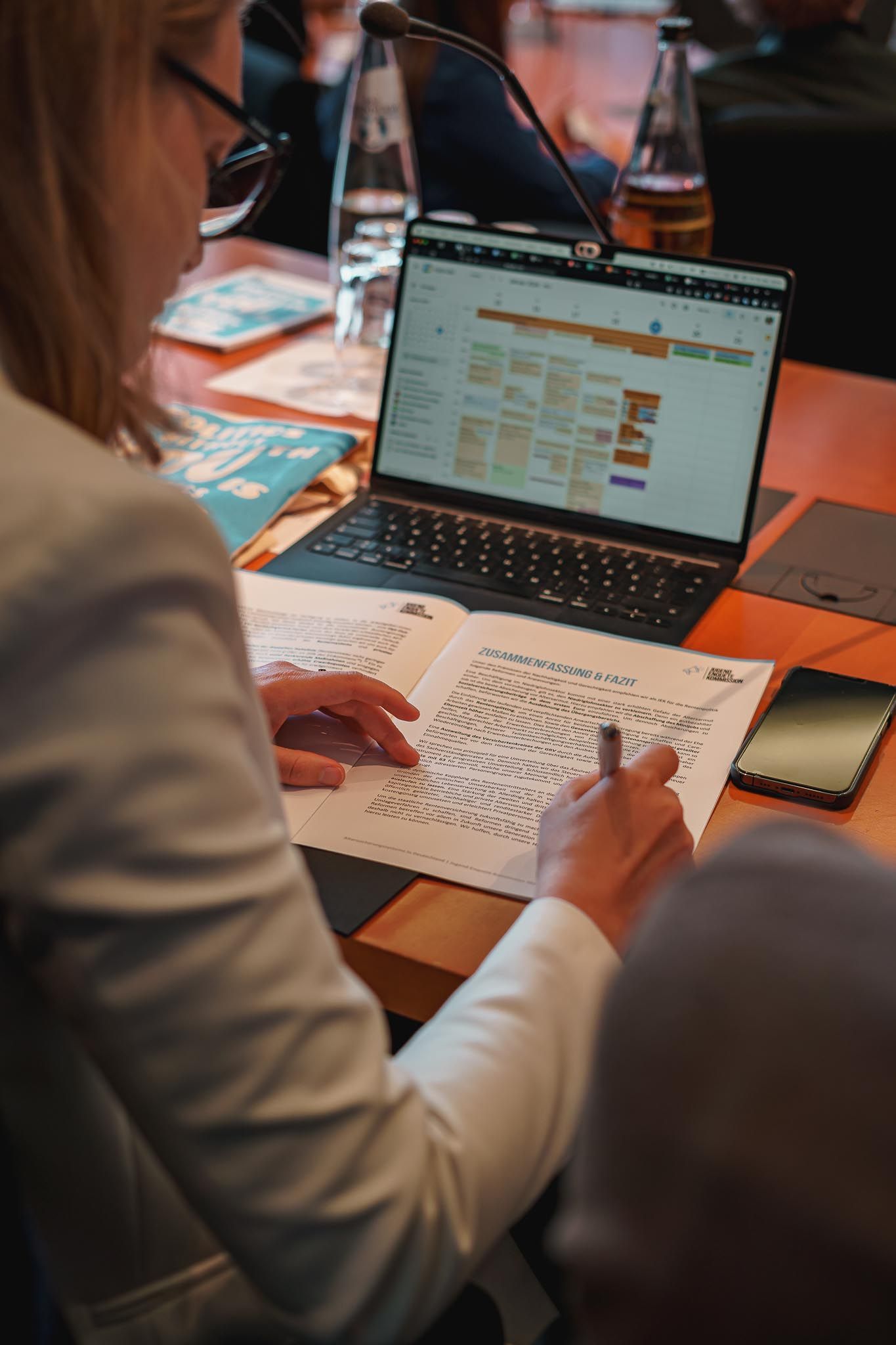 Eine Frau macht vor ihrem Laptop auf einem Blatt notizen, von Fotograf Hannes Schmidt in Aachen