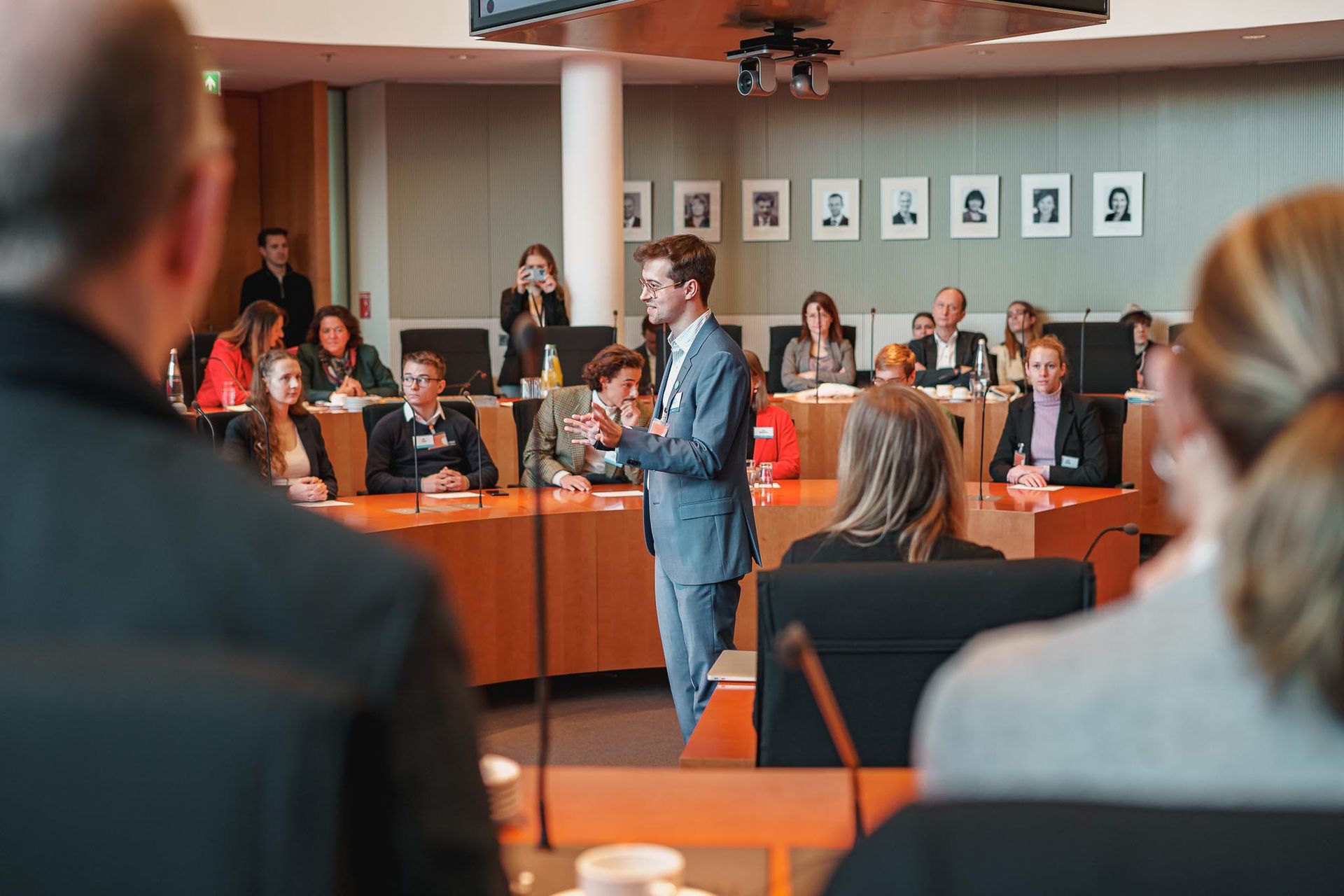 Sprecher von der JEK e.V. spricht in einem Kreisrunden Saal, von Fotograf Hannes Schmidt in Aachen