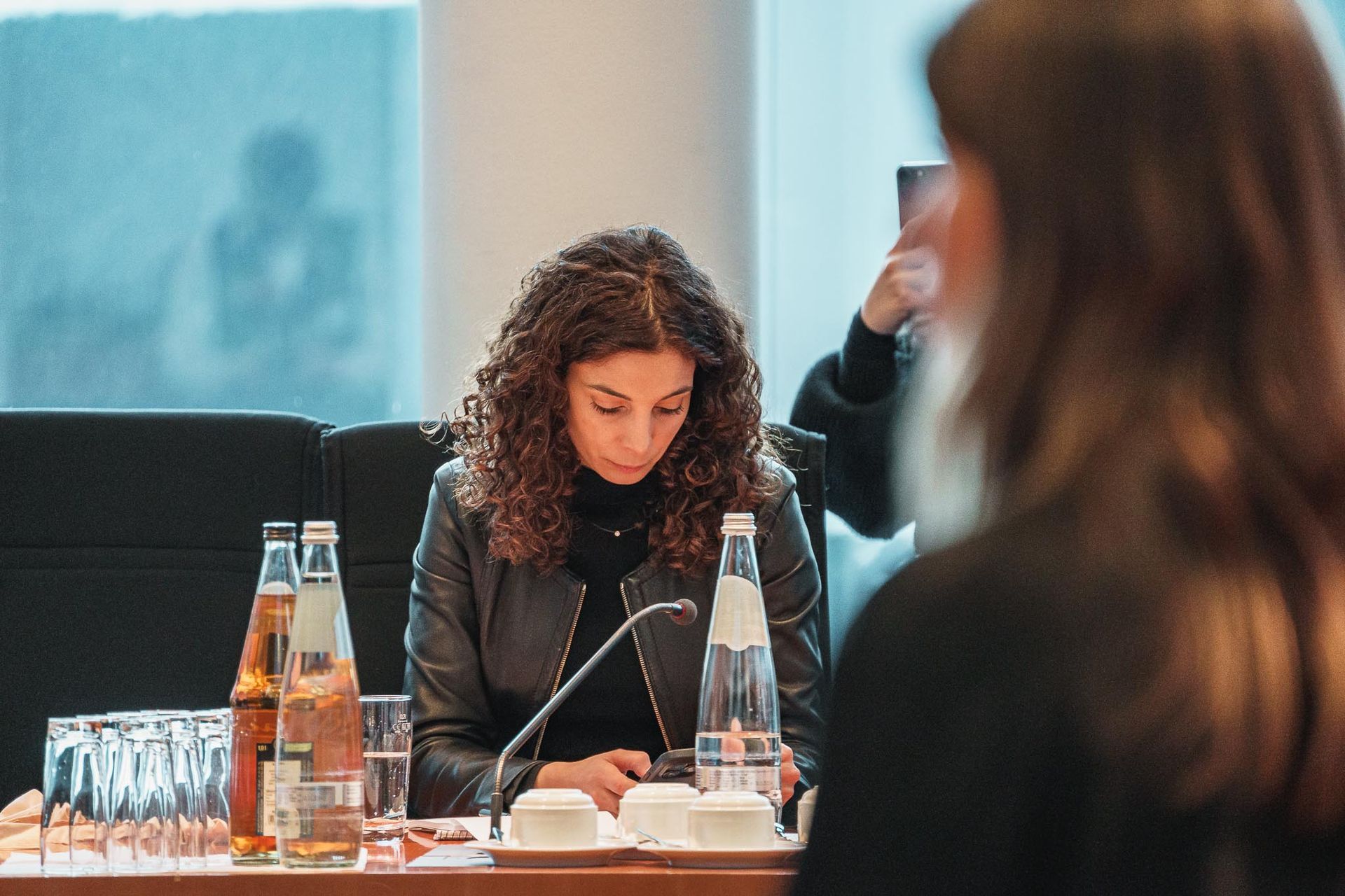 Mitarbeiterin des Bundestags schau am Tisch auf ihr Handy, von Fotograf Hannes Schmidt in Aachen