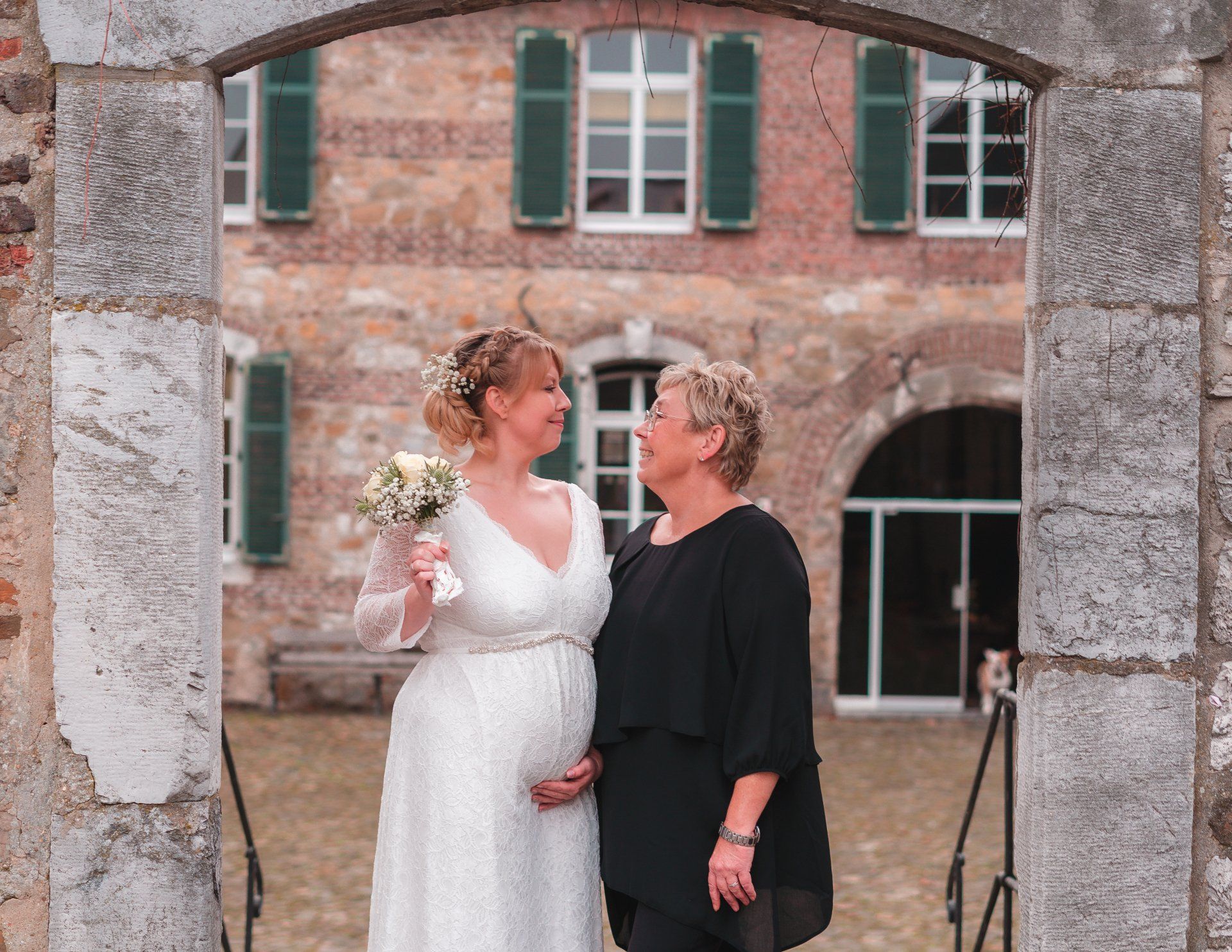 Braut Und Mutter stehen im Tor und lächeln von Fotograf Hannes Schmidt in Aachen