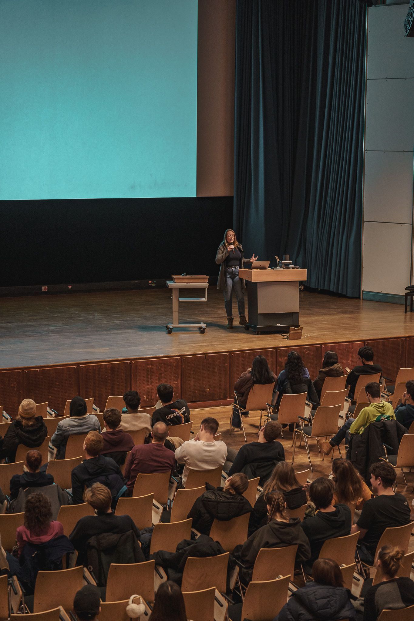 Teilnehmerin auf der Bühne beim Vortragen bei PowerPoint Karaoke von Fotograf Hannes Schmidt in Aachen