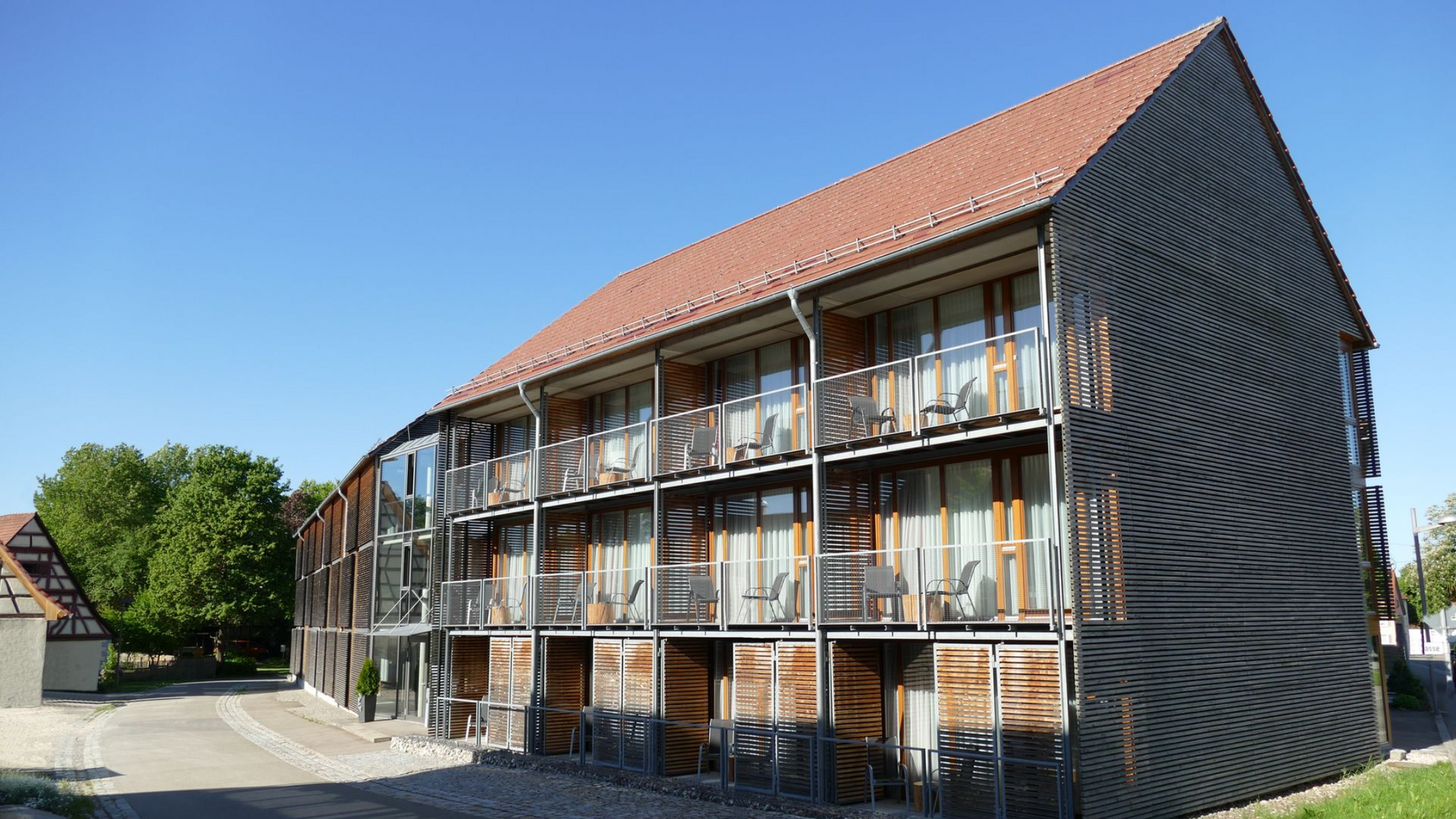 Außenansicht des Hotels Speidel’s BrauManufaktur mit moderner Holzfassade und Balkonen, im Herzen der Schwäbischen Alb.