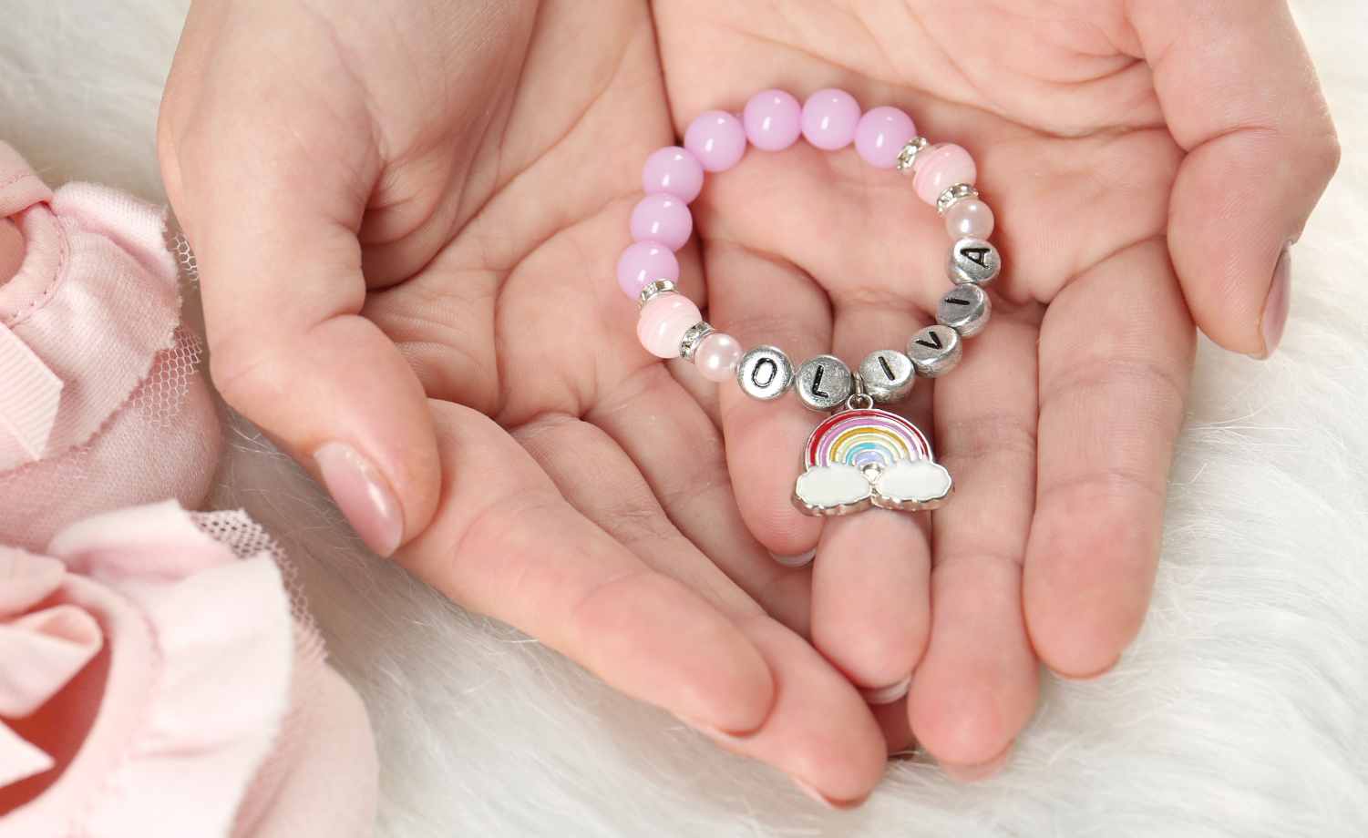 hand holding new born baby girl bracelet