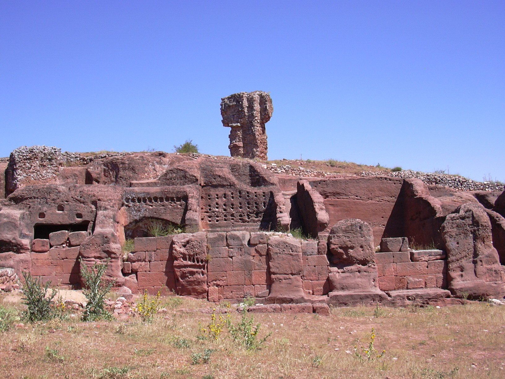 Graderío excavado en la roca roja del yacimiento arqueológico de Tiermes, Soria.