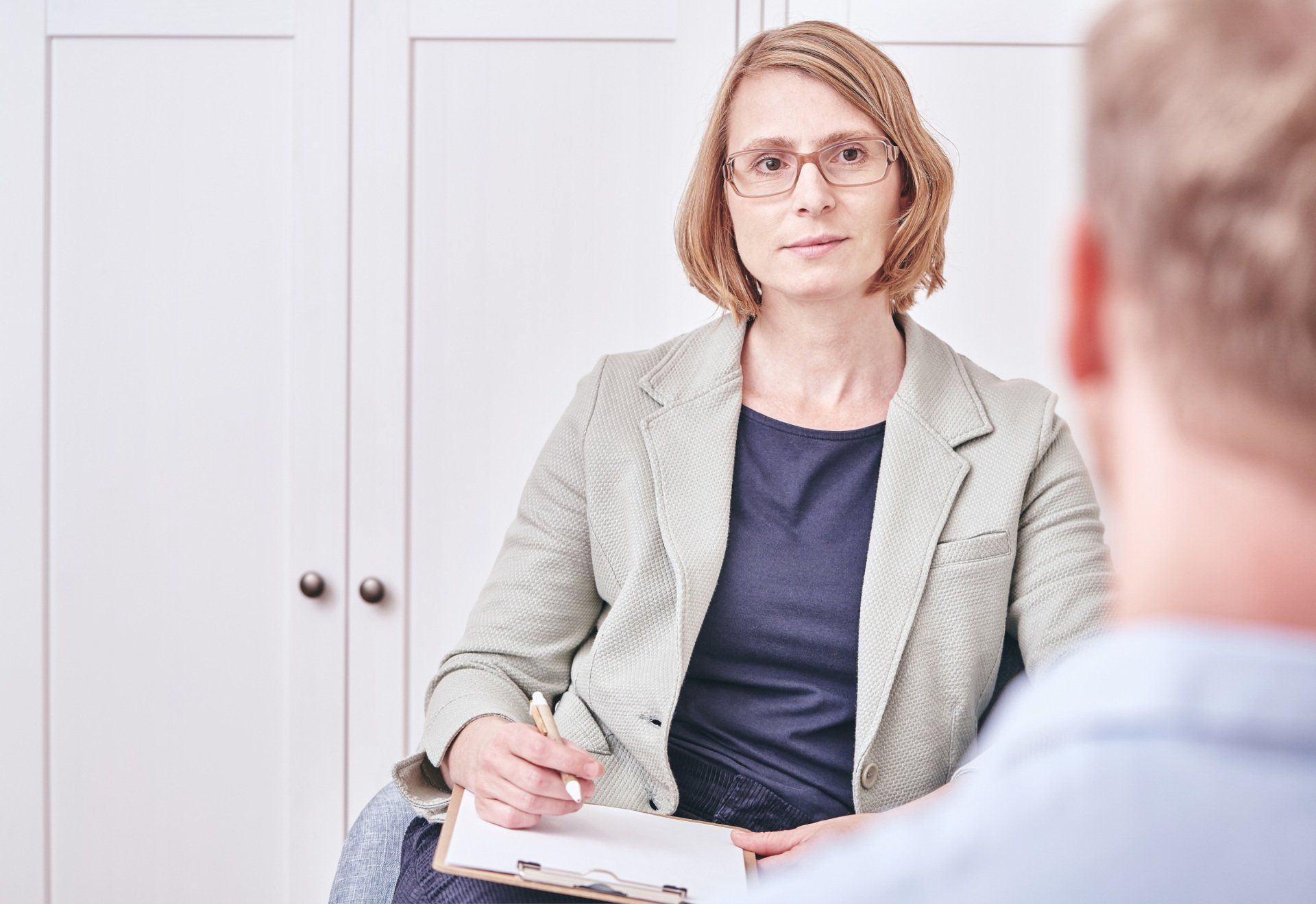 Mareike Paulus im Coachinggespräch Coach im Coaching mit Klienten, Coach ist dem Coachee zugewandt, welcher nur von hinten zu sehen ist