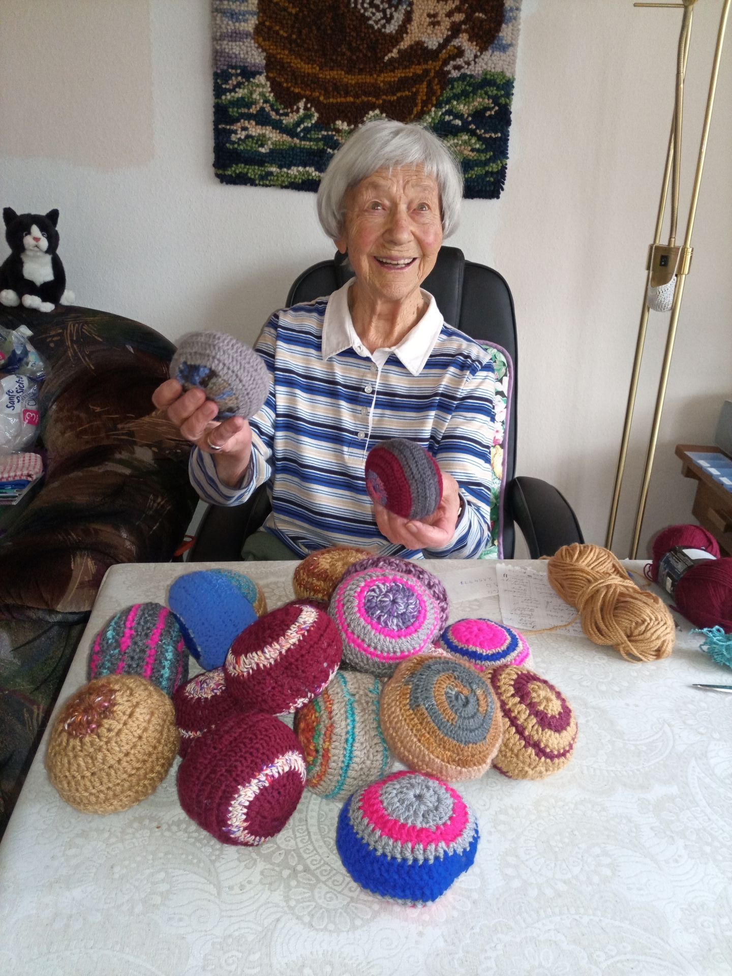 Zu sehen ist Frau Kirschner mit vielen bunten Wollknäuel, welche sie selbst gehäkelt hat.