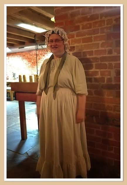 im Bremer Geschichtenhaus, die junge Frau im historisch angelehnten Kostüm in olivgrün. mit einer weißen Schürze, eine Mütze auf dem Kopf, sie begrüßt uns und wird uns zur ersten Station führen.