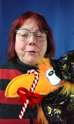 Jahresrückblog2023, Britta, oranger Rabe, die Handpuppe im Zaubererkostüm, rot-weiße Zuckerstange
