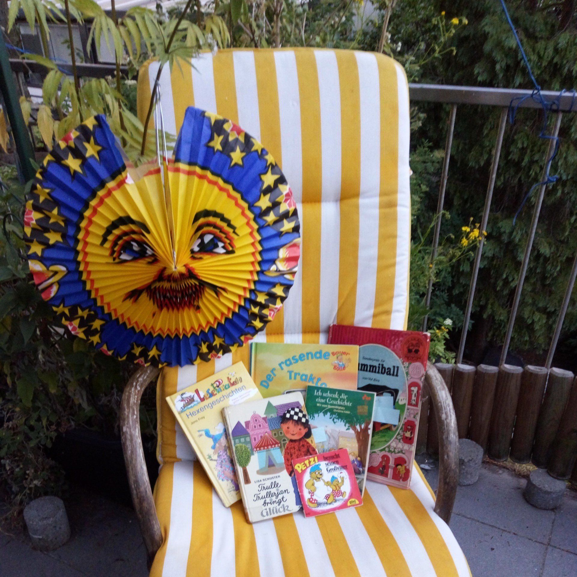 Auf einem Stuhl liegen Kinderbücher. An der Lehne hängt eine Laterne mit einem Mond und den Sternen, © Foto Britta Ogasahara Auf einem Stuhl liegen Kinderbücher. An der Lehne hängt eine Laterne mit einem Mond und den Sternen, © Foto Britta Ogasahara