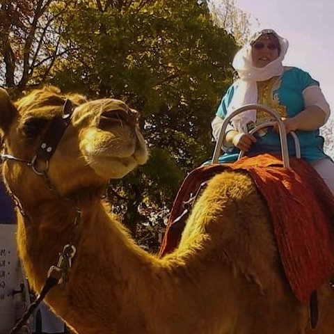 oben auf einem Dromedar, © Foto Britta Ogasahara, Frau in hellblauen Kaftan, Mit weißem Turban auf einem Dromedar, © Foto Britta Ogasahara,