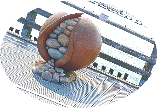 Kunst auf der Seebrücke, ein rundes Objekt, in dessen Inneren man Steine sehen kann