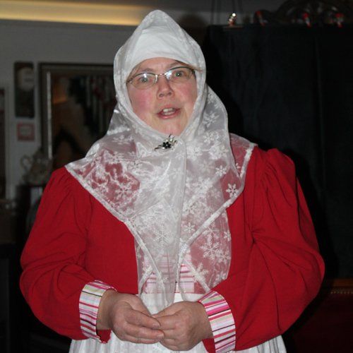 Cafe`Törtchen;die Märchenerzählerin begüßt die Gäste; roter Rock, weiße Schürze,