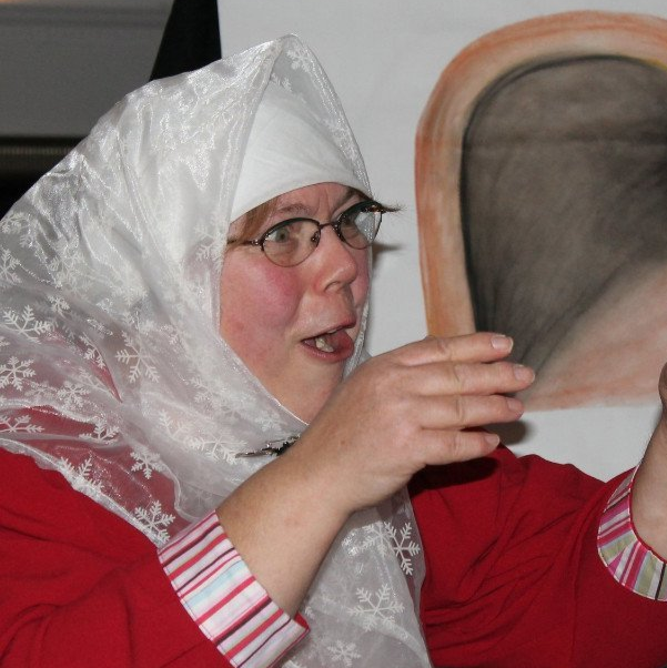 Interaktion mit dem Publikum, Lebendiges Erzählen; rotes Kostüm mit weißer Schürze, weißes Kopftuch, Photo Britta Ogasahara©