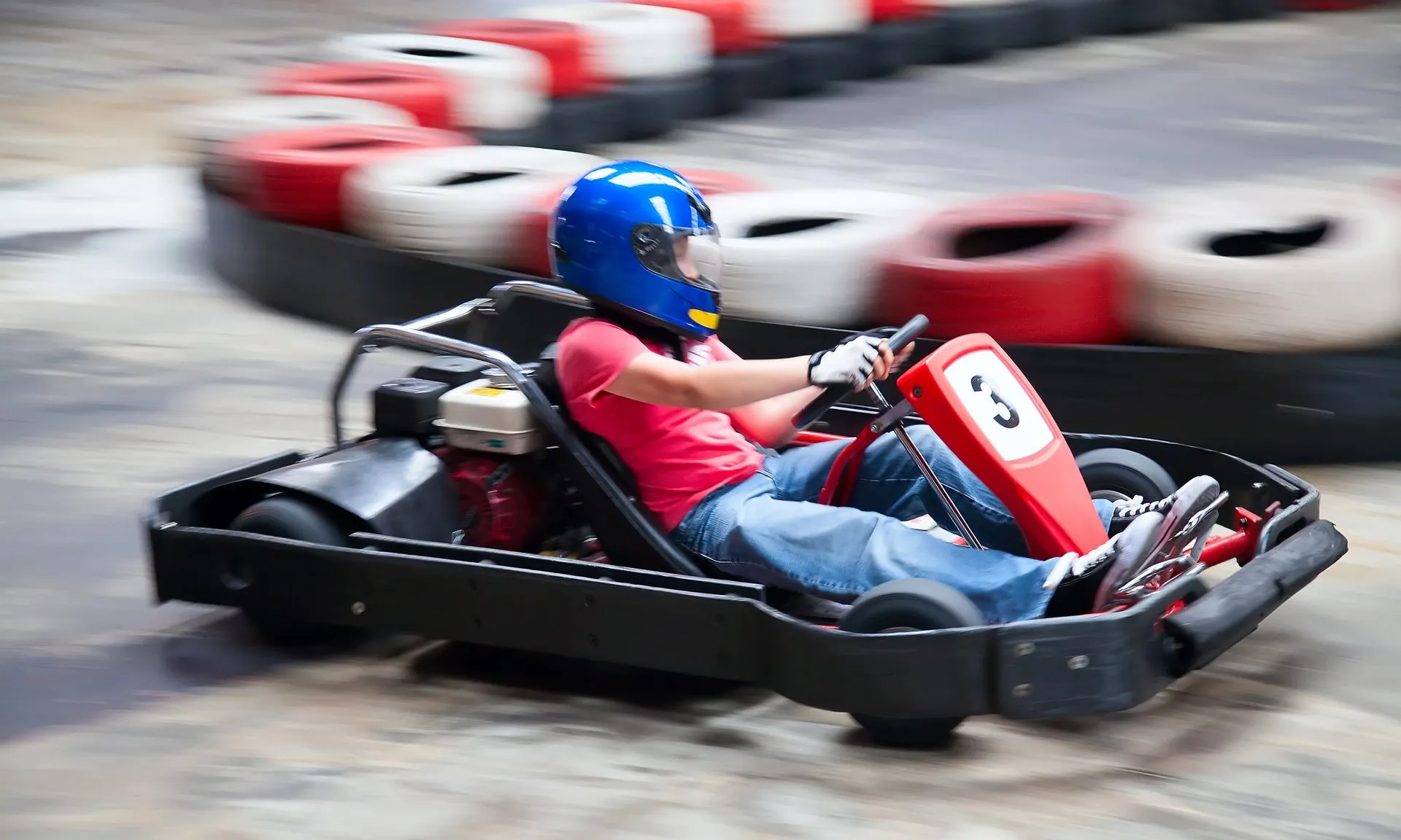 es ist ein Kind in einem Go-Kart zu sehen, das ein Rennen auf einer Go-Kart-Bahn fährt