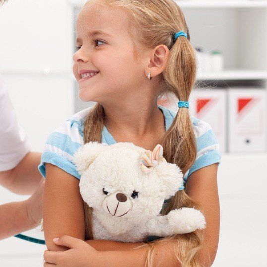 ein Mädchen hat einen Teddybär auf dem Schoß