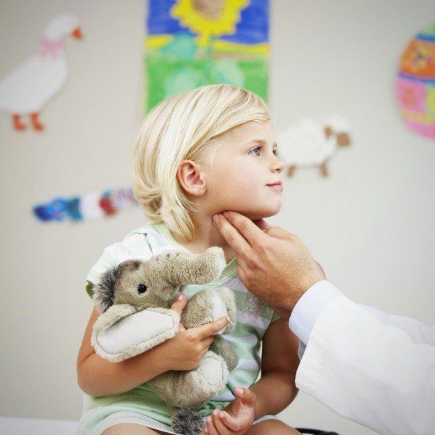 es ist ein Kind zu sehen mit einem grauen Kuscheltierelefanten im Arm, das am Hals abgetastet wird um Lymphknotenschwellungen festzustellen