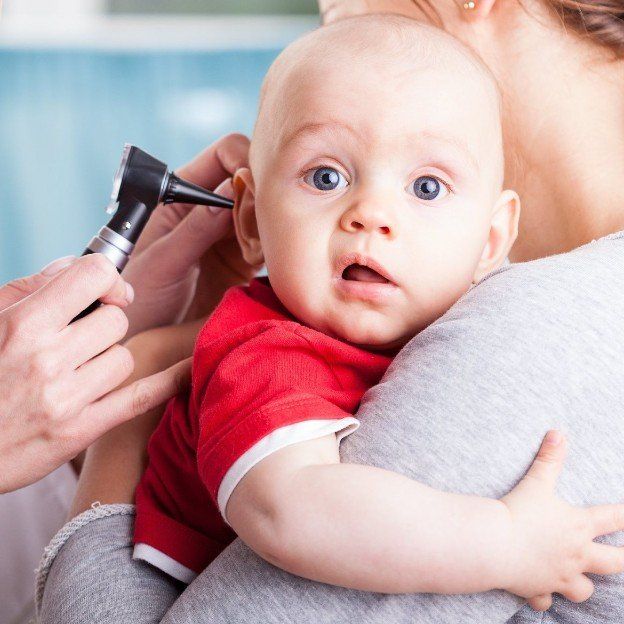 das Ohr eines Säuglings wir mit Hilfe eines Otoskop untersucht