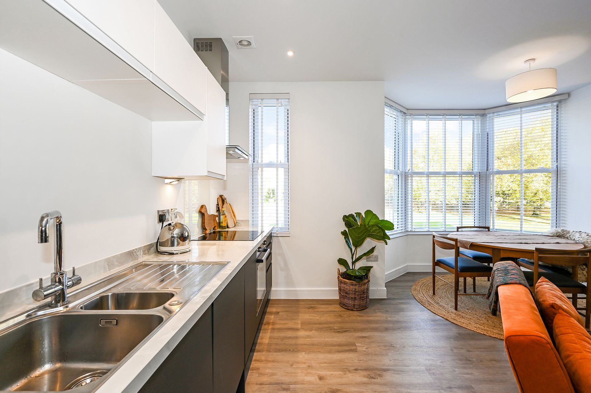 A new build kitchen in a light and bright flat with an orange sofa