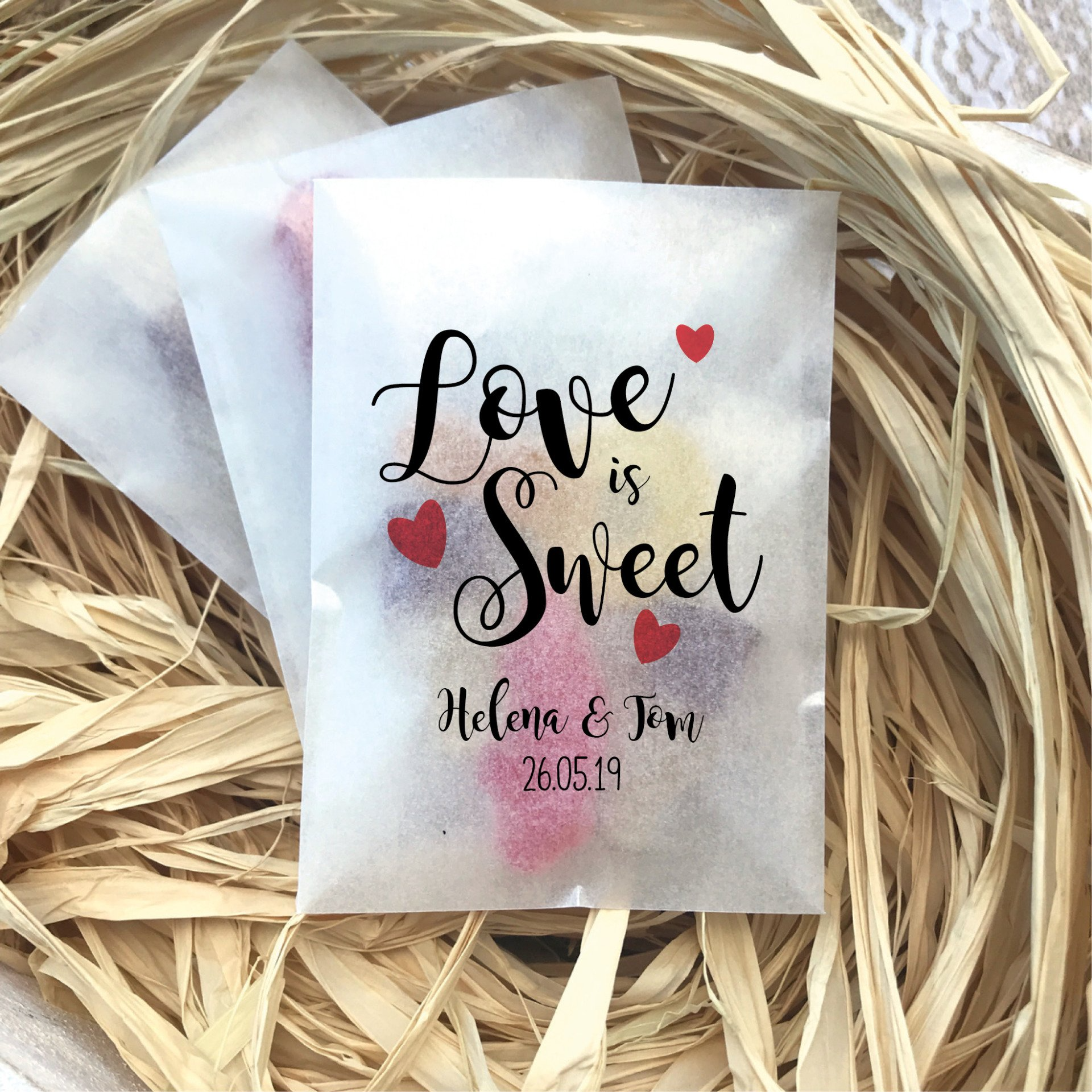Eco-friendly biodegradable glassine bag wedding favour printed with ‘Love is Sweet’ design.