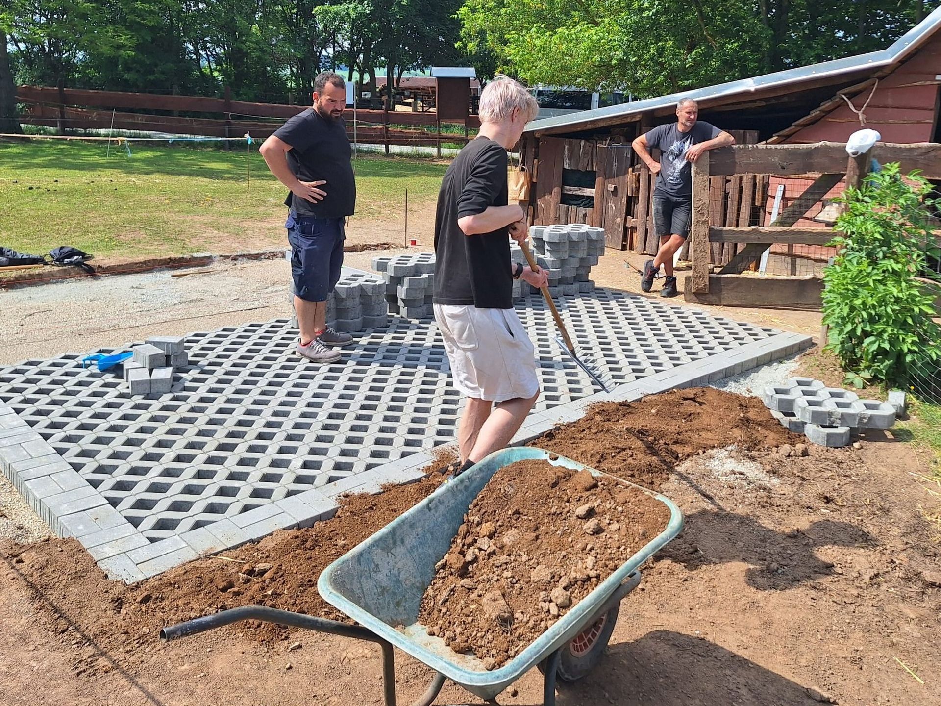Jugendliche verfestigen den Boden im Eselgehege für die neue Futterraufe