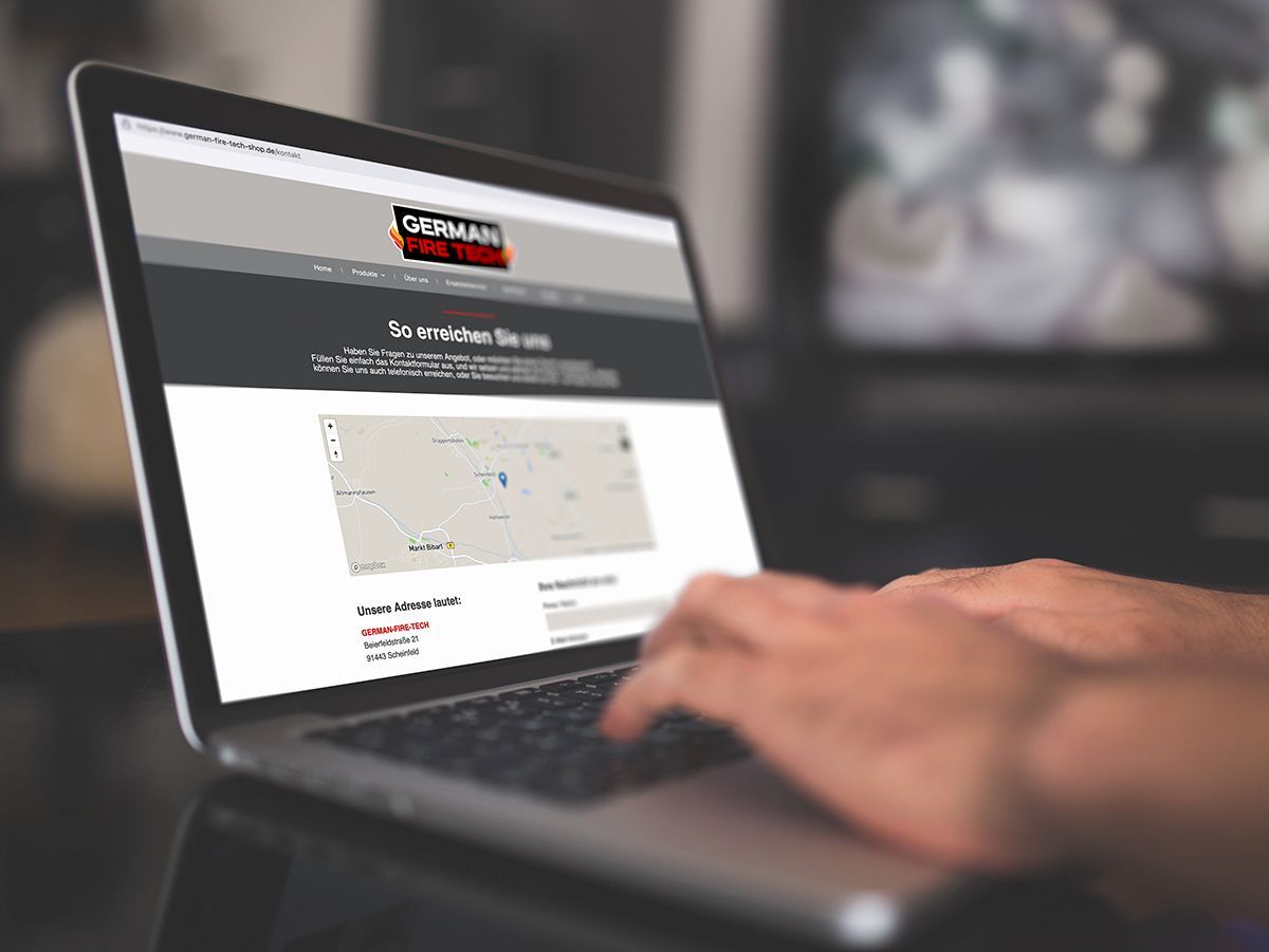 Das Bild zeigt eine Person am Laptop - auf dem Display sieht man die Kontakt-Seite der Website von German-Fire-Tech.