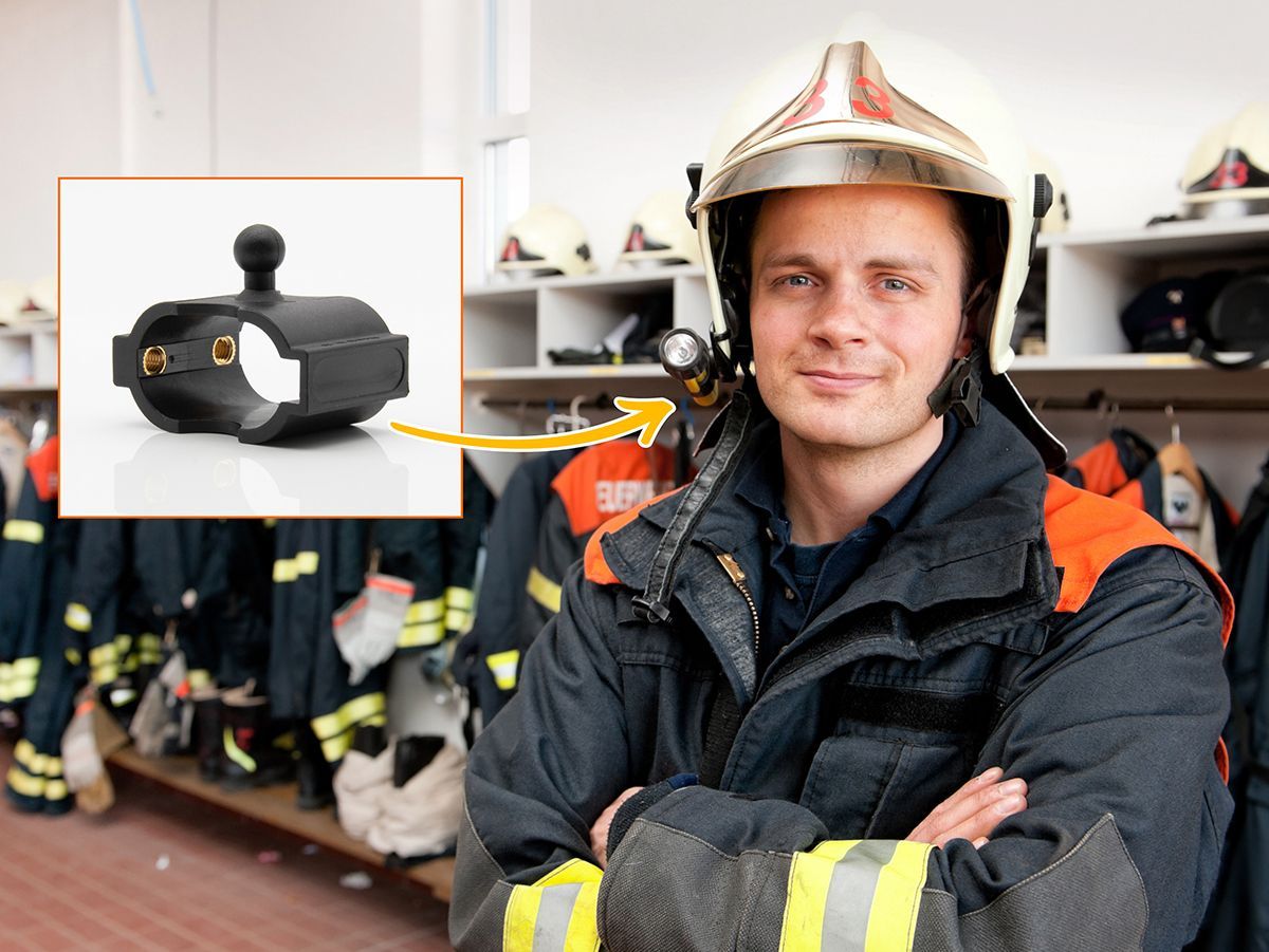 Das Bild zeigt einen Feuerwehrmann in Arbeitskleidung mit Helm im Umkleidebereich einer Feuerwache. Eine weitere Abbildung darüber zeigt das Ersatzteil ERS_oval.