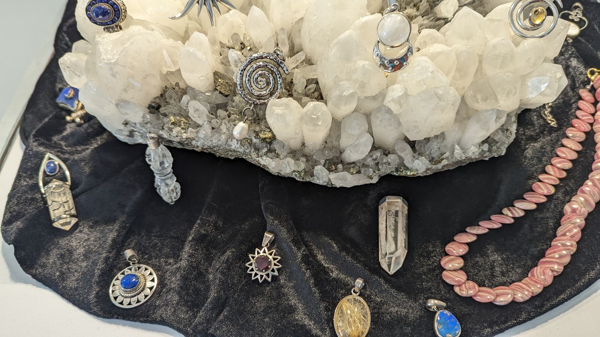 Mehrere Silberschmuckstücke präsentiert auf einem Milchquarz. Die unterschiedl