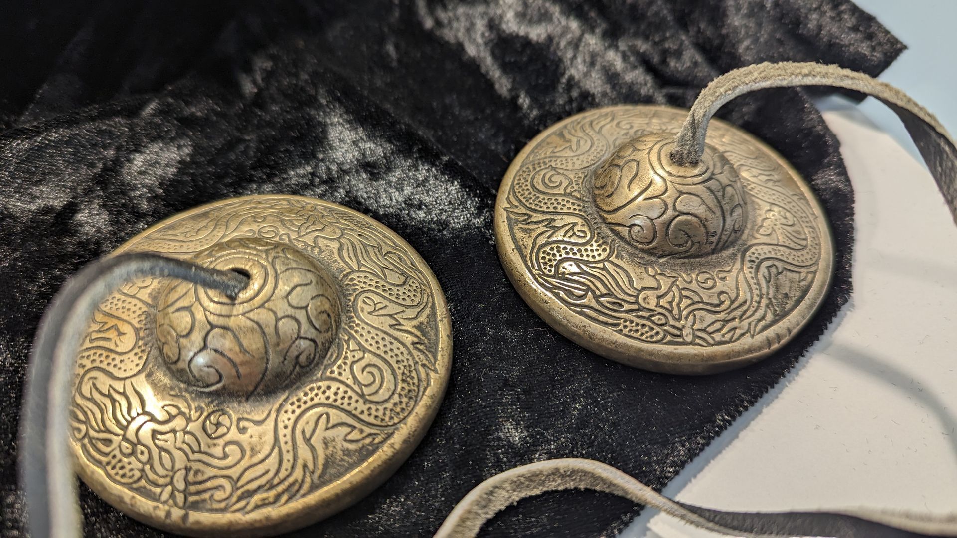 Zimbeln liegen auf einem schwarzen Pannesamt